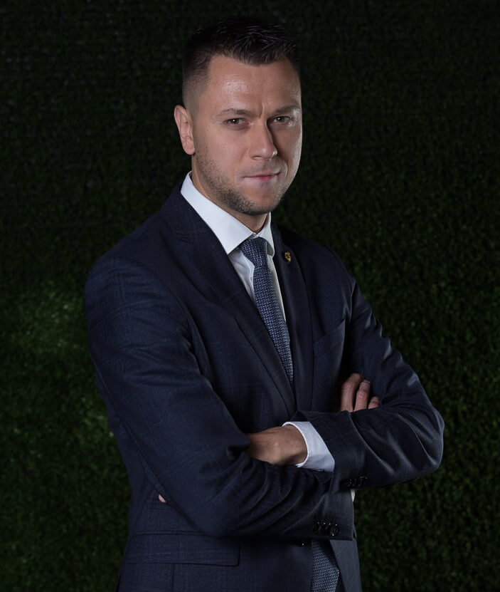 Man wearing a suit with a serious look looking straight into the camera