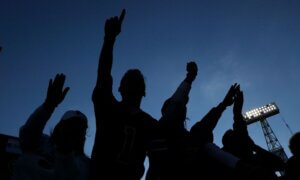 The shadows of fans watching a game at an outdoor stadium