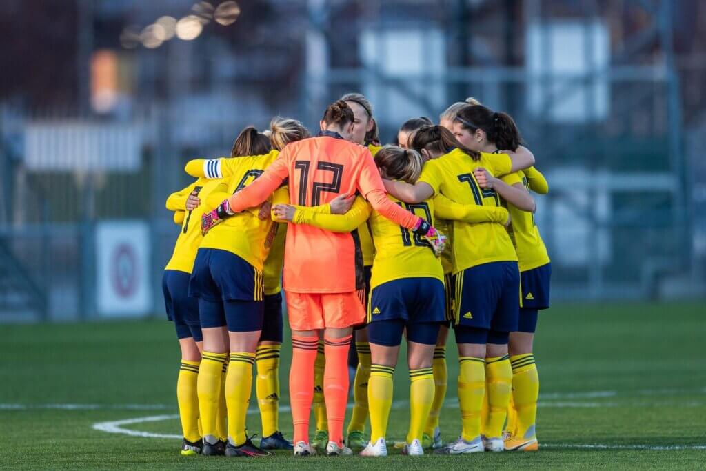 Female football team having a peptalk