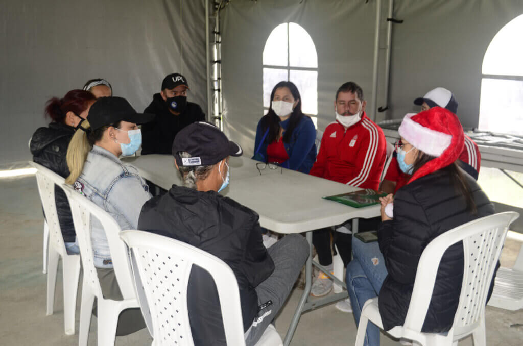 A group of people sitting around a table inside of a large tent