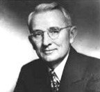An old, black and white picture of a man wearing a suit and glasses