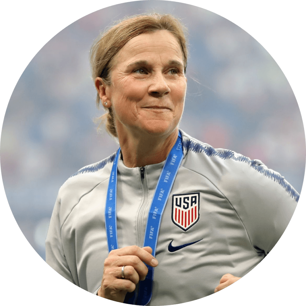 A picture of a middle aged woman with a half smile wearing a USA sports sweater and a FIFA band around her neck