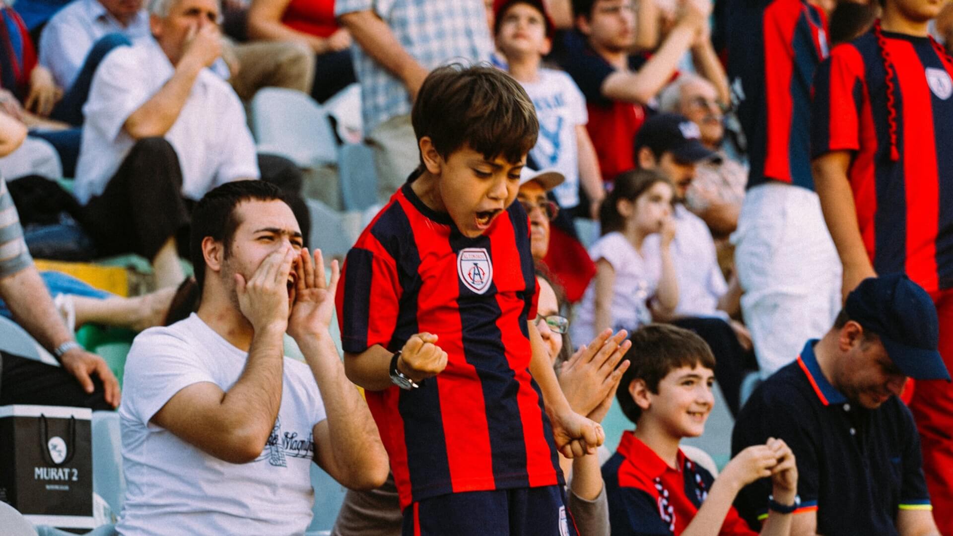 An excited football fan fist bumping the air thanks to 1:! supporter interaction