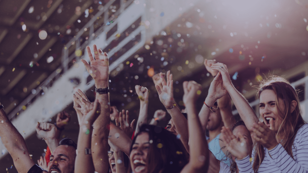 A crowd cheering in the stands to show the event tickets market worth